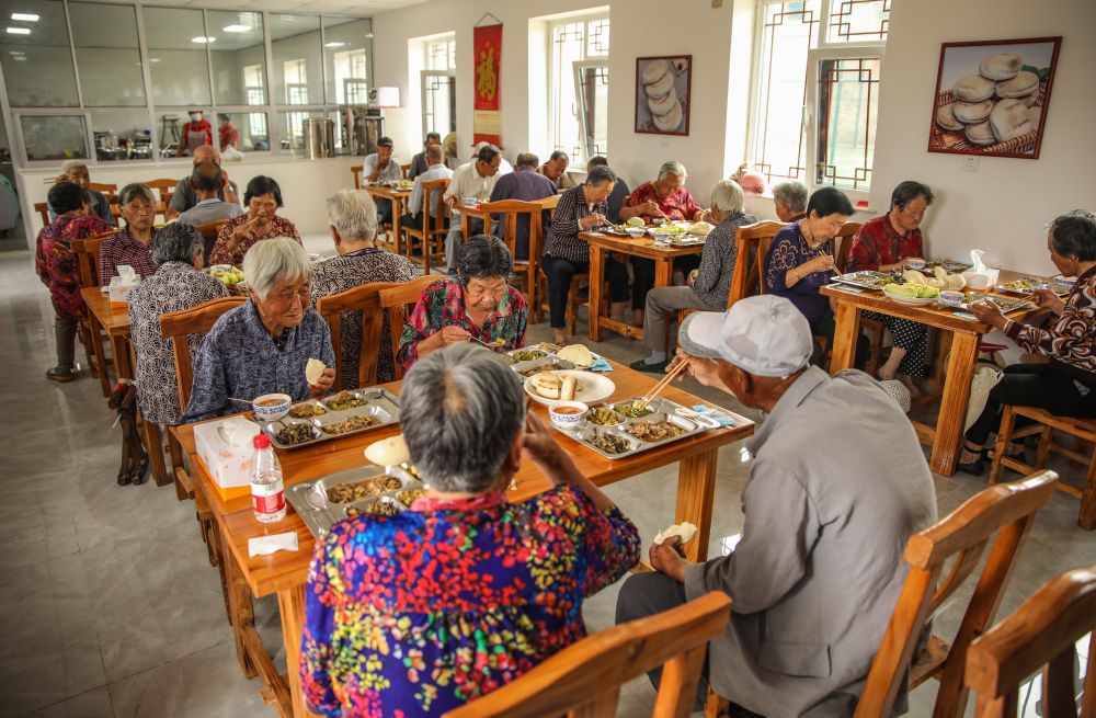为破解居家养老吃饭难,山东省荣成市全面推进“暖心食堂”建设。这是2020年7月4日,老人们在荣成石岛管理区斥山街道盛家村“暖心食堂”内用餐。