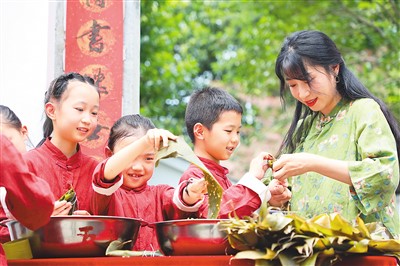 　　近日，浙江省杭州市淳安县汾口镇小学的学生在老师的指导下包粽子，做香囊，了解端午节的来历和习俗，感受端午节的文化内涵。　　图为老师指导学生包粽子。　　谢航凯摄（人民视觉）