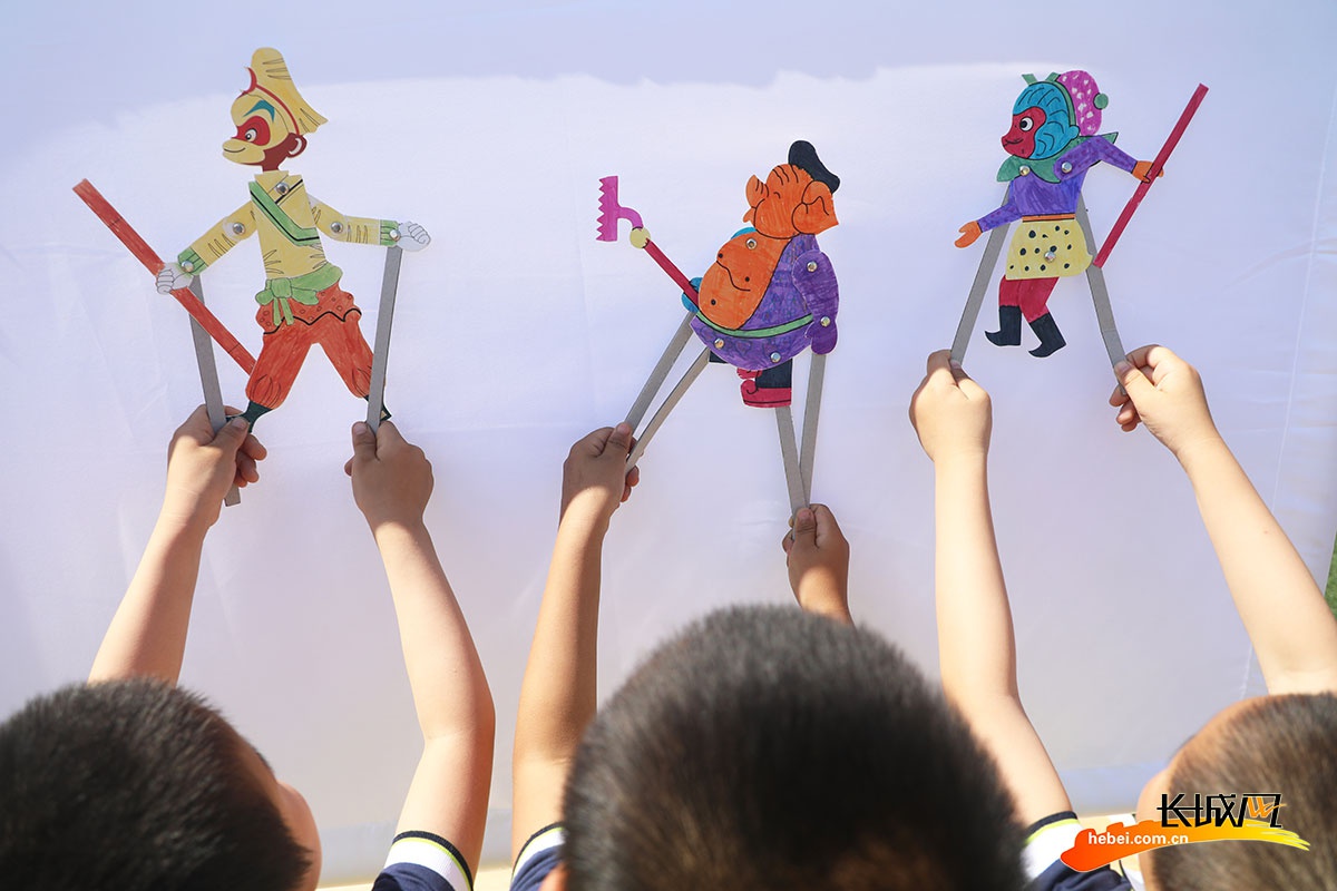 市丰润区白官屯镇燕子河幼儿园"非遗大集"上,小朋友们在表演皮影戏