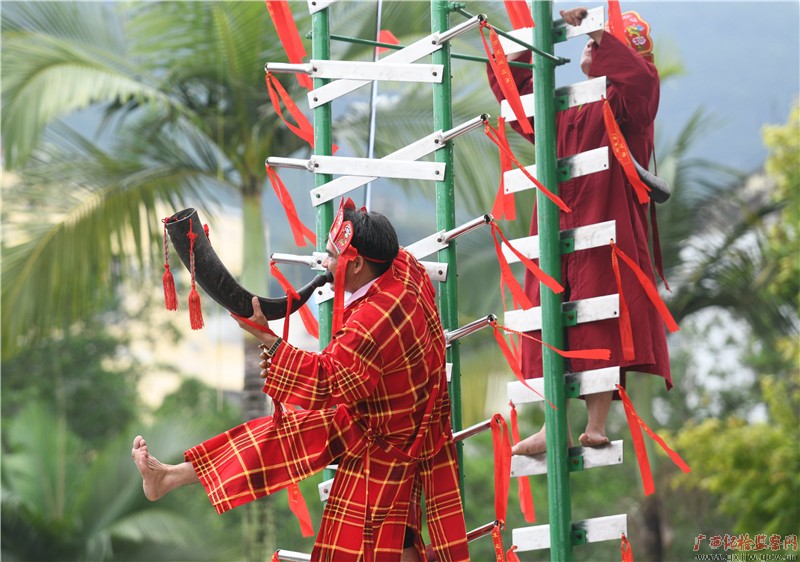    In the National Culture Square of the Mulao Autonomous County, Luocheng, folk artists are performing traditional sports and acrobatics 