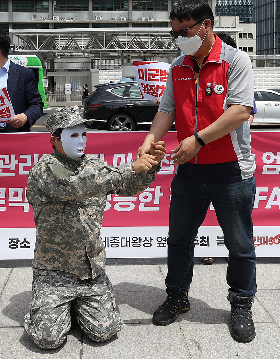 16日，美大使馆前，韩国民众给“驻韩美军罪犯”戴手铐