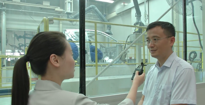 记者在奇瑞新能源汽车公司生产车间进行采访。