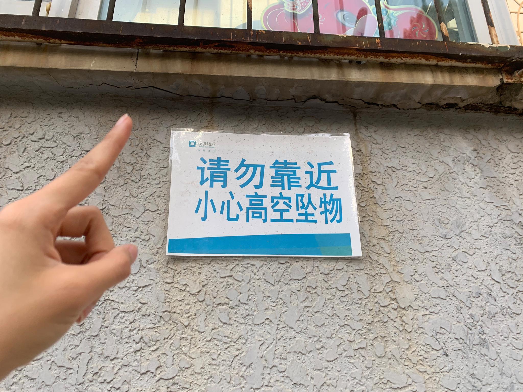 的提示牌说,前阵子北京频频遭遇大风天气,水泥墙皮脱落的情况多次发生