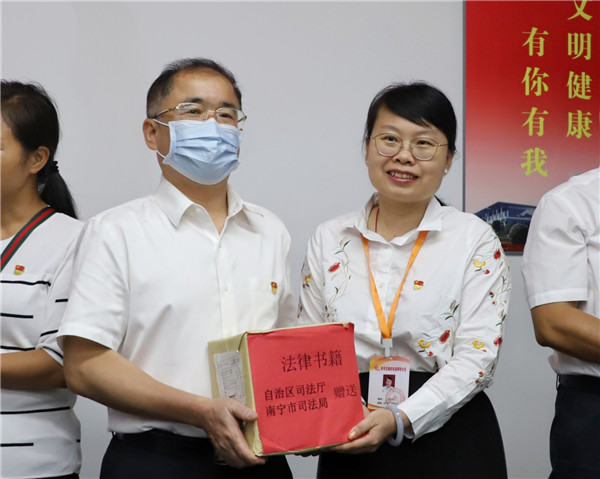 林金文向茅桥社区工作人员赠送法律书籍.王瑜 摄