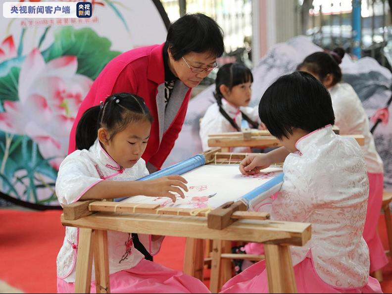 △梁雪珍老师与市桥中心小学学生一起进行广绣展演。