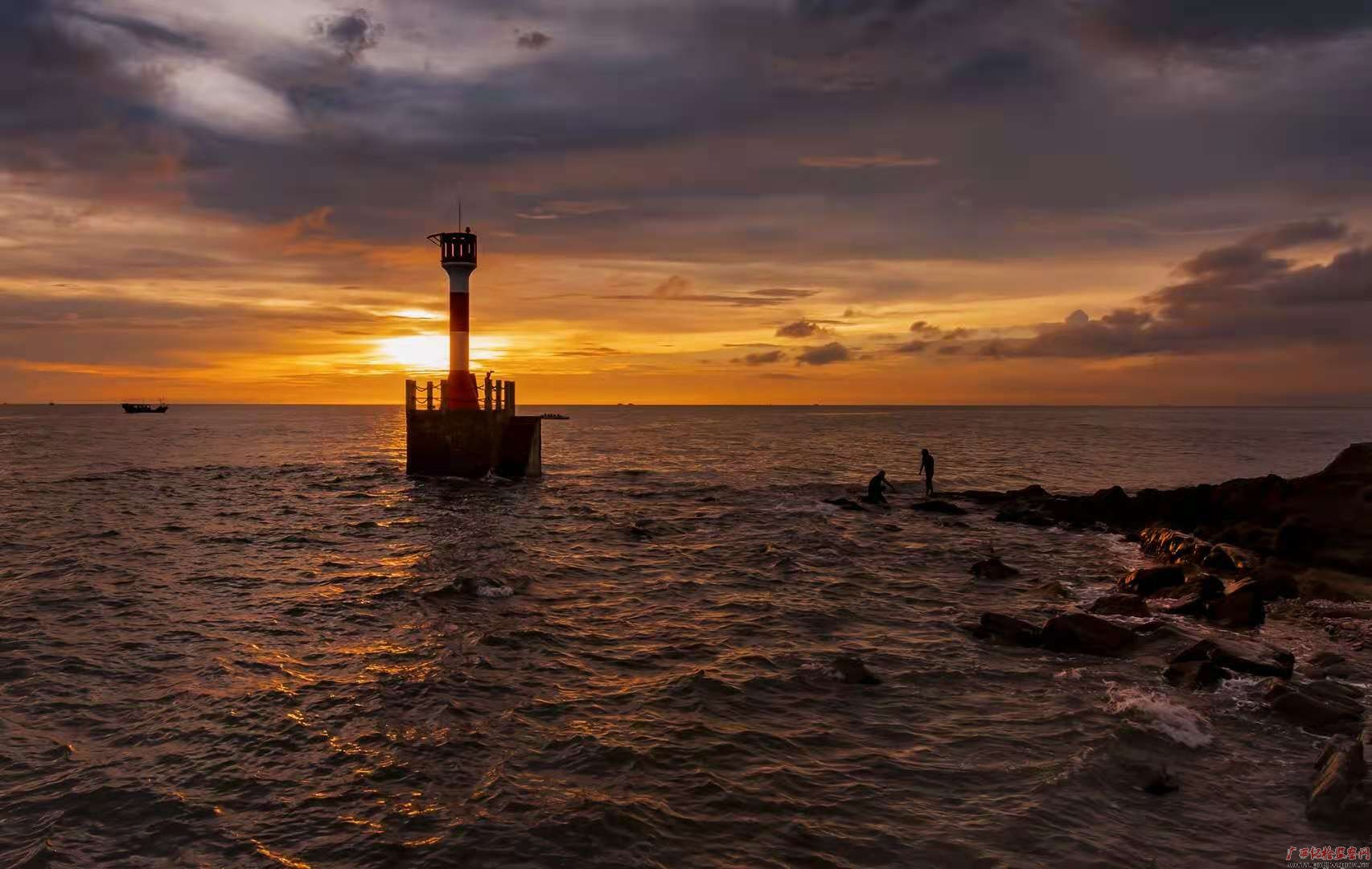 夏至的晚霞将北海市冠头岭国家森林公园染得一片通红,海上的灯塔,海边