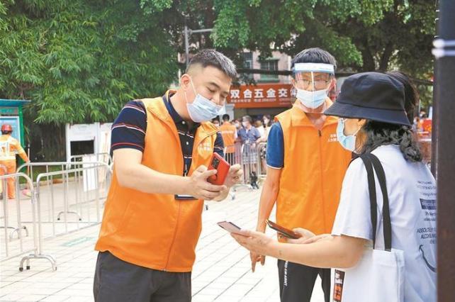 ▲郭磊在黎光社区核酸采样现场指导居民填报信息。受访者供图