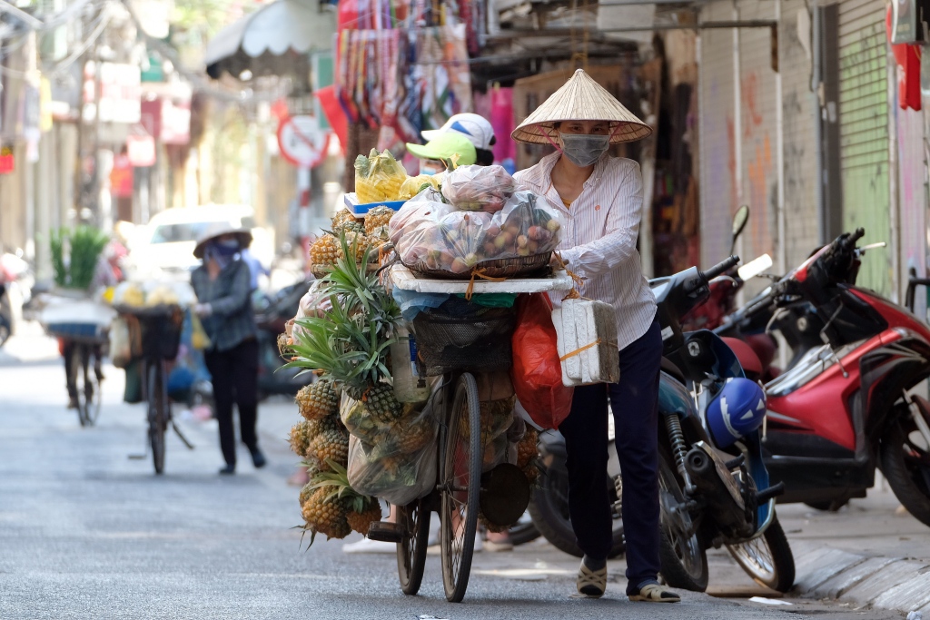 越南民众佩戴口罩出行。
