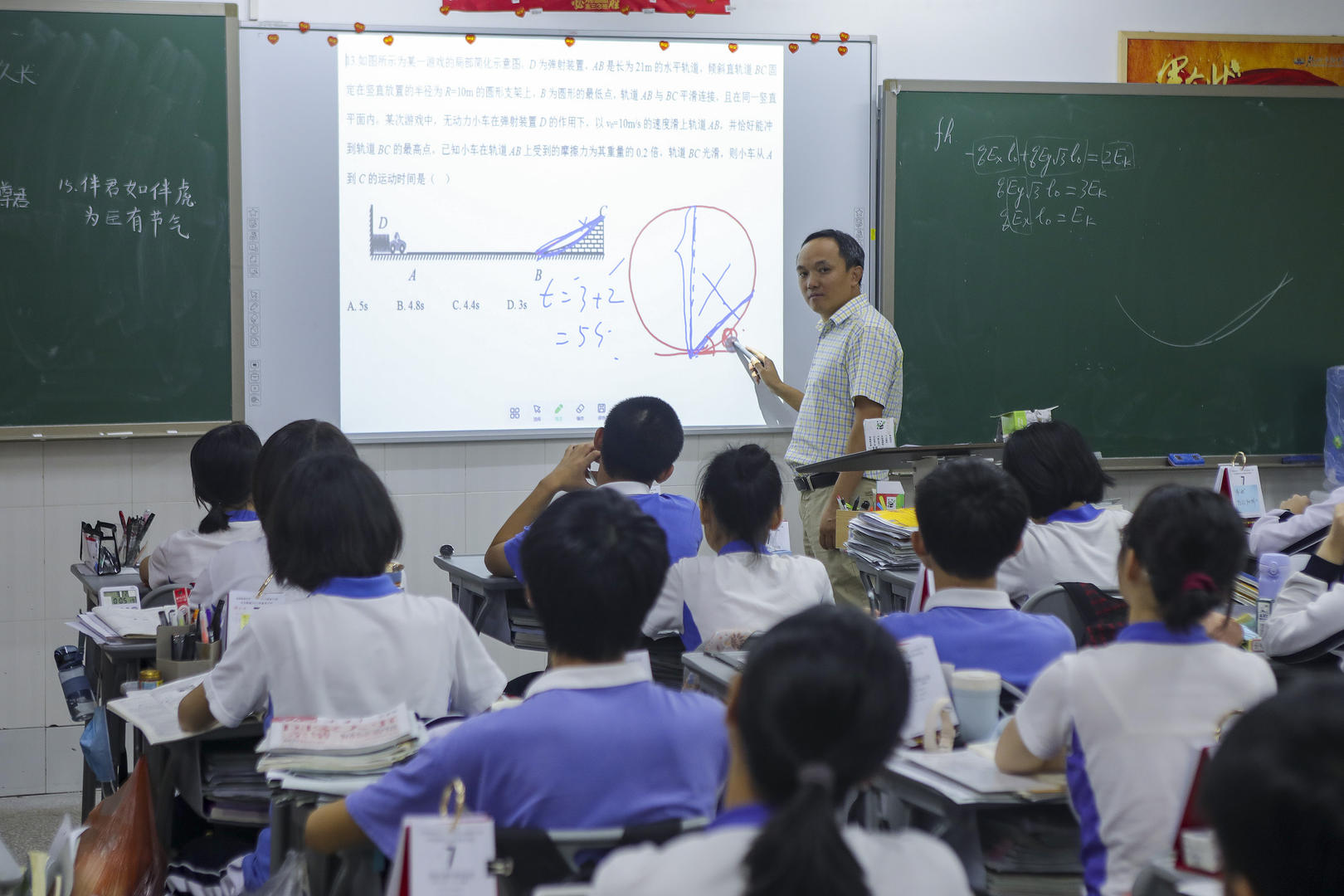 2021年5月31日，深圳龙城高级中学，老师为学生讲解试卷难点。图据视觉中国