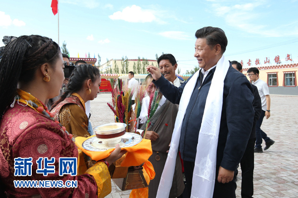 这是2016年8月22日下午,习近平在海西蒙古族藏族自治州格尔木市唐古拉山镇长江源村考察时接受村民献上的青稞酒。新华社记者 庞兴雷 摄