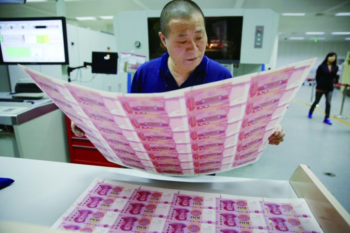 在北京印钞厂印码部,对于部分质量存疑的产品,工人一一取出检查 记者