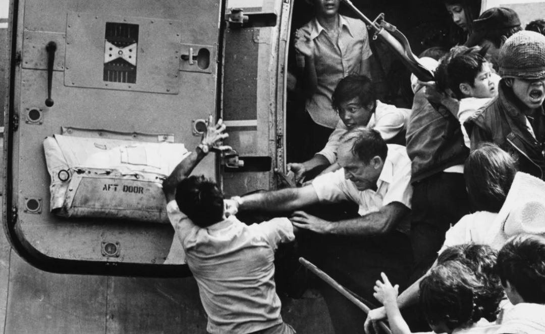 图为1975年4月30日西贡陷落时，一名希望搭乘飞机逃往美国的当地男子，被一名美国人一拳揍下飞机的场景