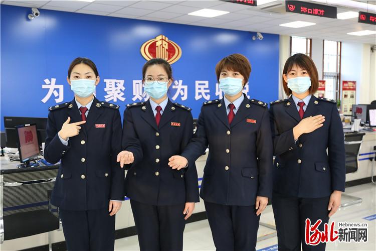 图为廊坊开发区税务局办税服务厅工作人员摆出我为您服务的手势.