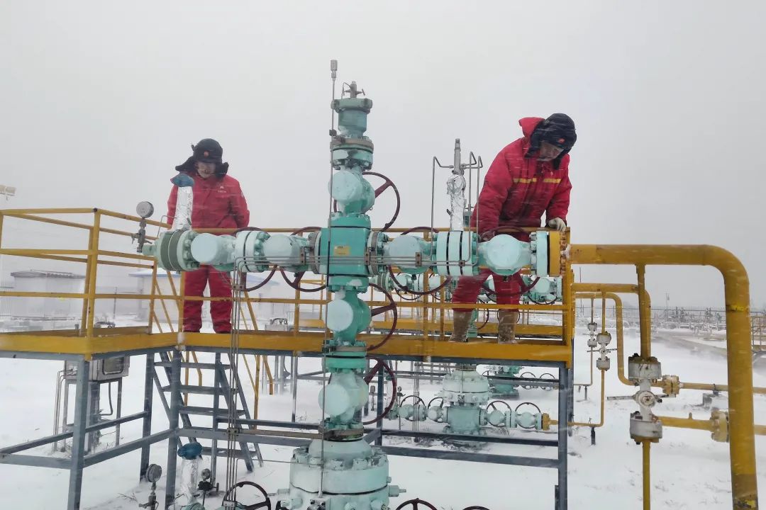 Employees in the operation area of ​​the board 808/828 gas storage against wind and snow conduct inspections on the wellsite and record the readings of the oil pressure gauge.Photo by Zhai Huijuan