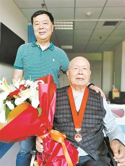 冷浩军在父亲冷鹏飞荣获“光荣在党50年”奖章时，与父亲的合影。 宴宏程摄