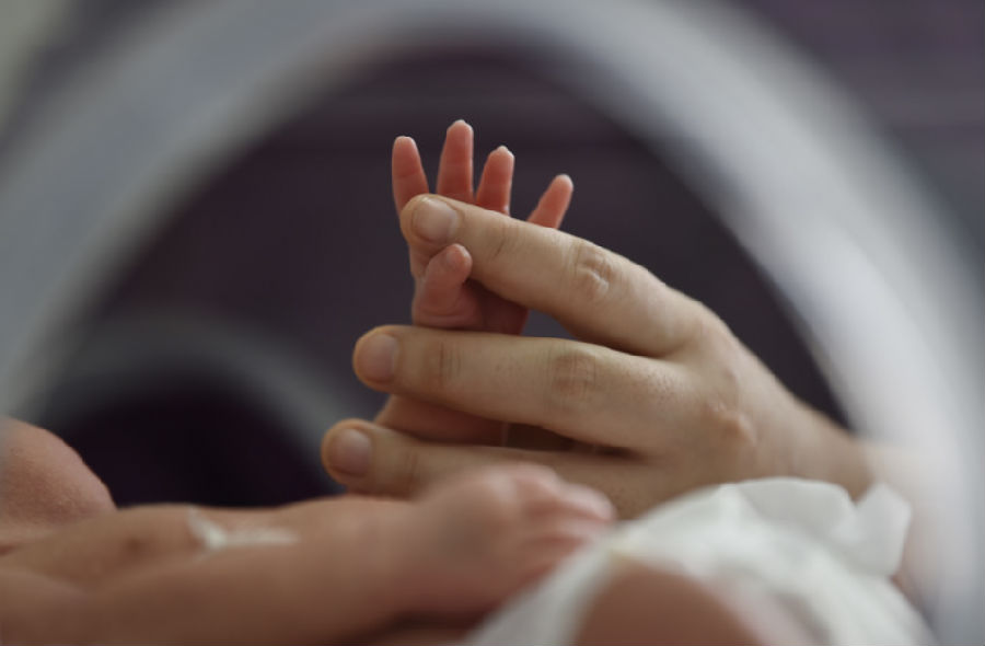 在江苏南京市江宁医院，医护人员跟一个新生儿握手。新华社发(方东旭 摄)