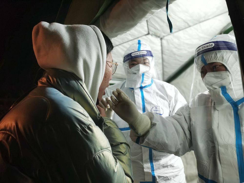 医务人员正在为天津市津南区双林街道象博豪庭社区内的居民进行核酸检测。（1月12日摄）新华社记者 刘惟真 摄