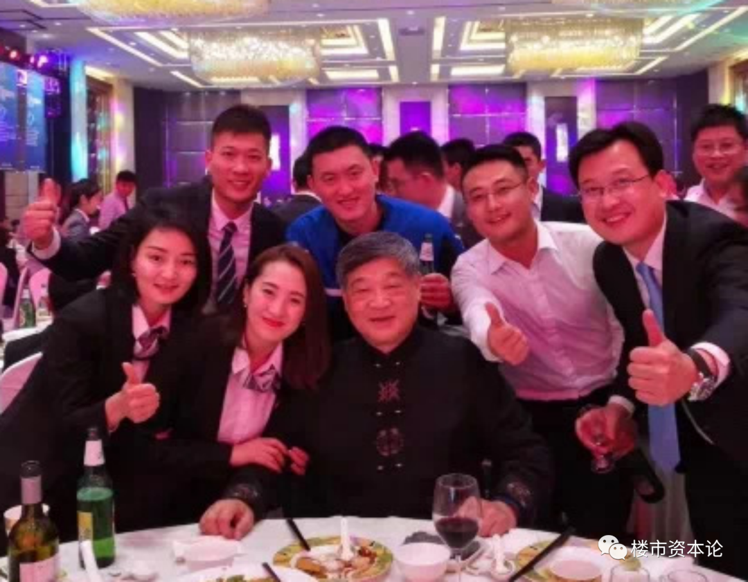 栾涛在酒桌前与员工温馨合影