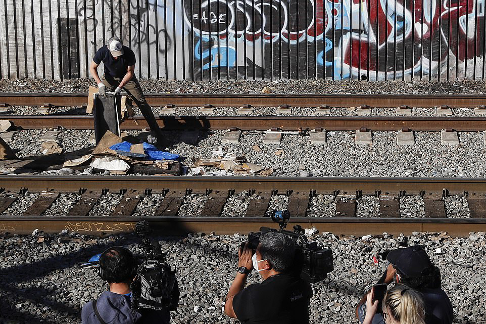 加文·纽森在清理垃圾，媒体人员在拍摄。图自推特