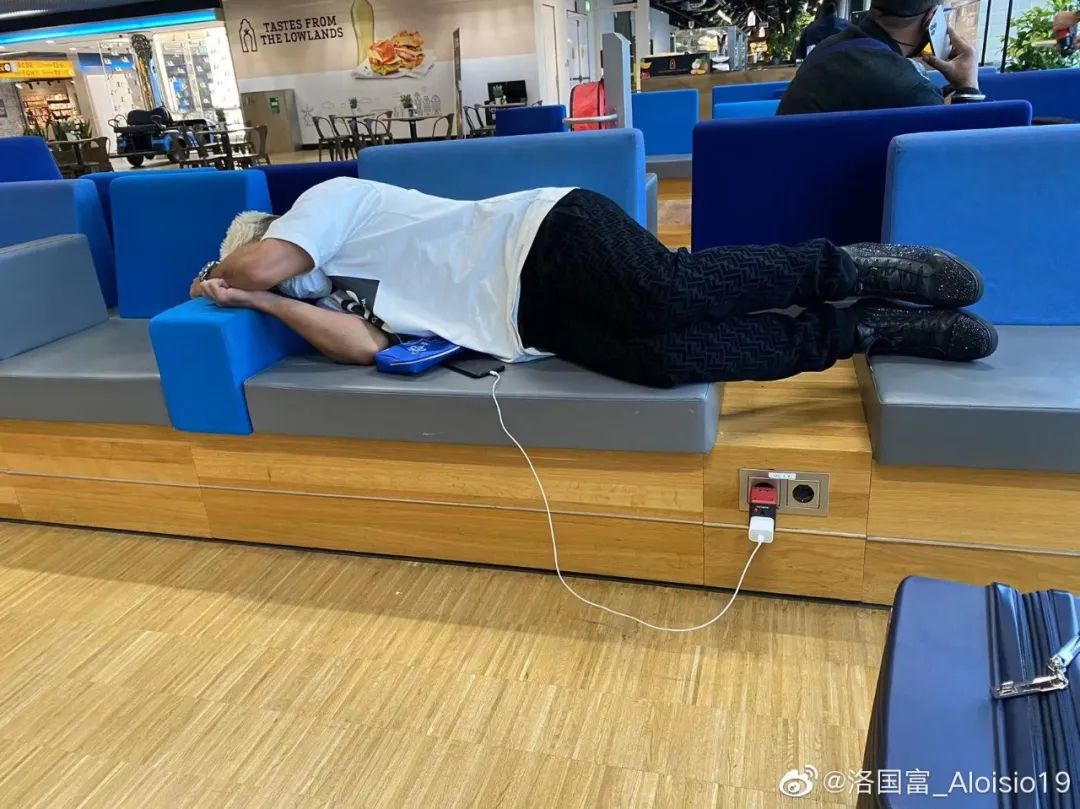 洛国富蜷缩在机场椅子上休息 图片来源：洛国富微博
