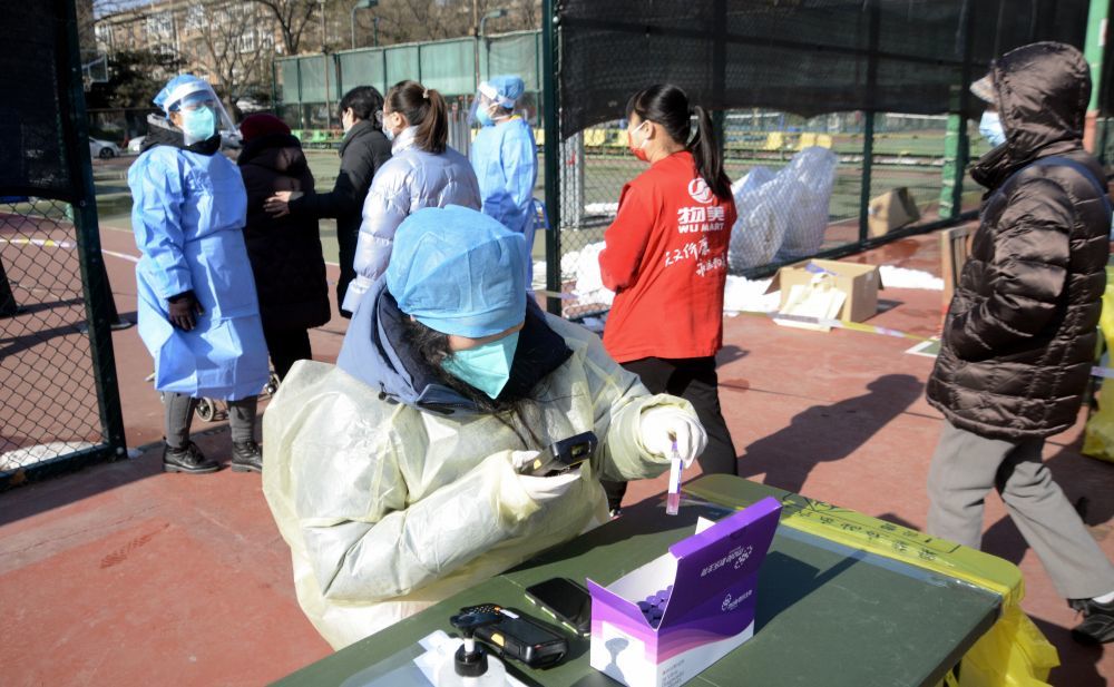 ↑1月25日，丰台区东高地街道的志愿者在核酸检测现场工作。