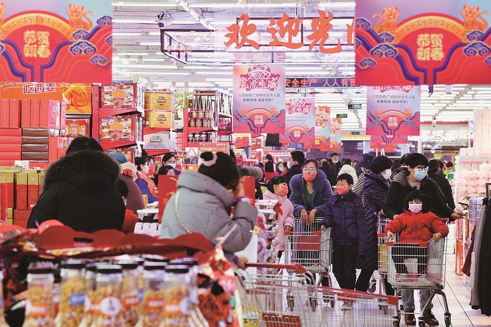 图为市民在装扮一新的超市年货大集置办年货.