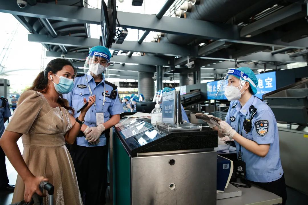 图为广州出入境边防检查总站白云边检站移民管理警察查验出入境旅客