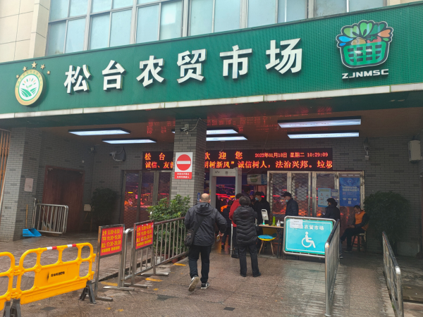 松台农贸市场门口,防疫人员正在进行严格查验.