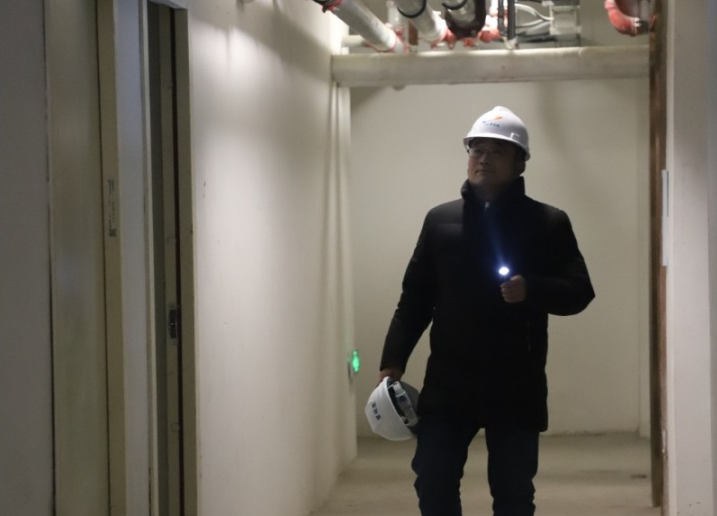 「王亚杰正在地下检测墙面腻子磨平情况」