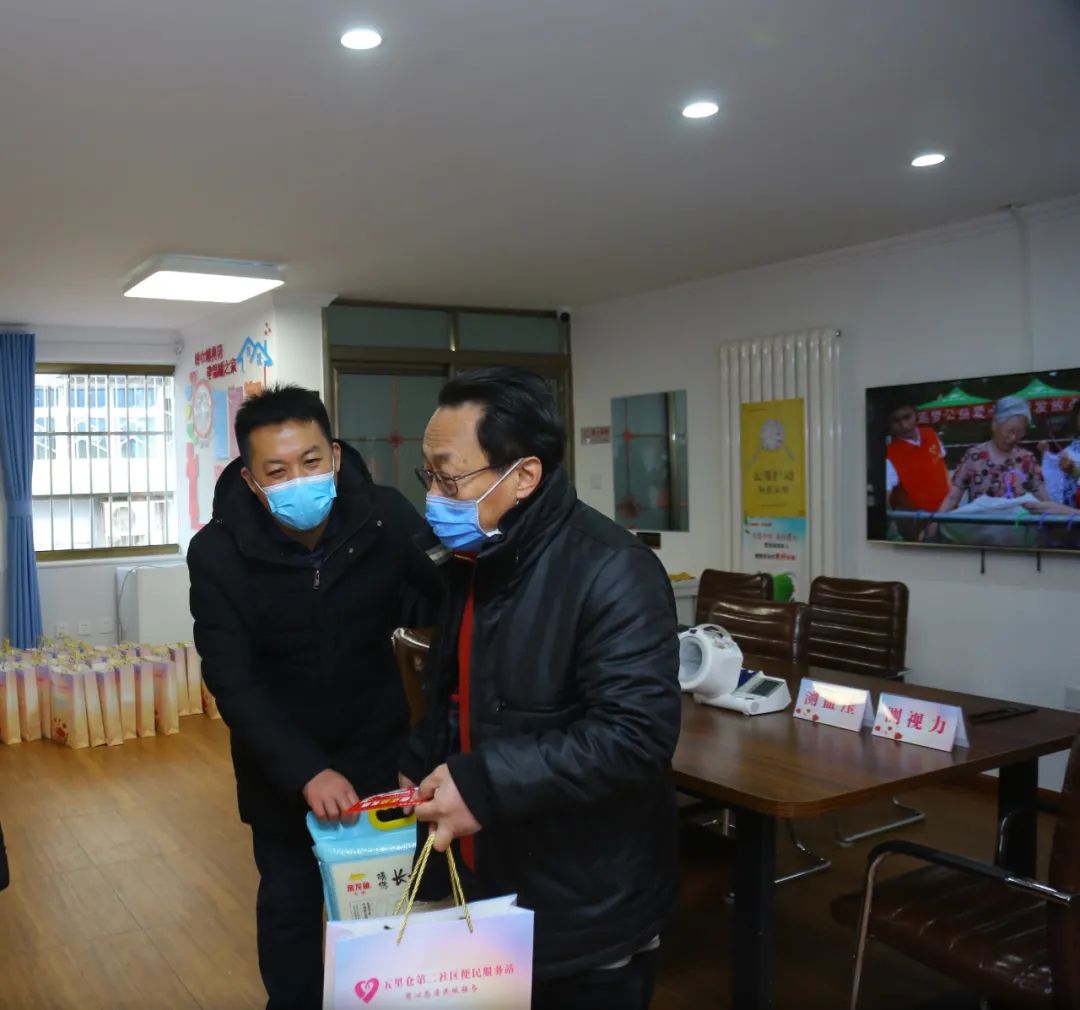 便民服务站负责人郭大军给社区老年人发放"年货大礼包"