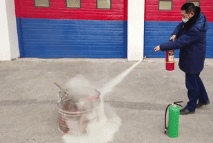 ▲使用灭火器要对准火焰根部、与起火点保持一定距离。