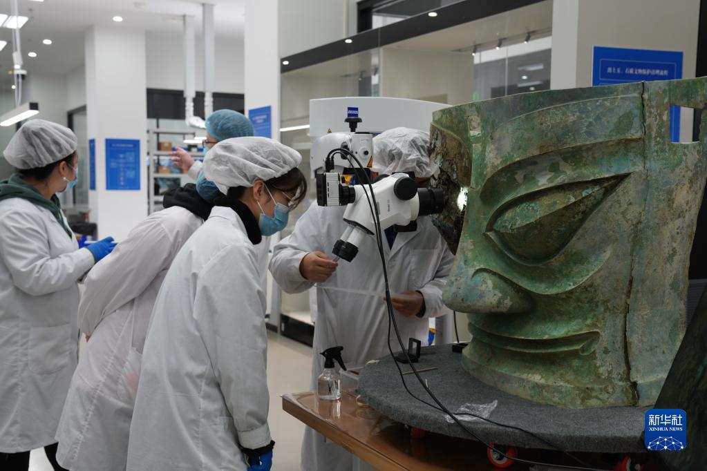 文保人员正在对三星堆遗址出土的青铜大面具进行修复（资料图片）。新华社发（国家文物局供图）