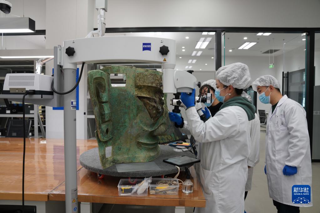 文保人员正在对三星堆遗址出土的青铜大面具进行修复（资料图片）。新华社发（四川省文物考古研究院、三星堆博物馆供图）