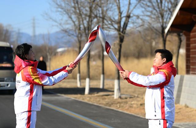 2月2日，火炬手李鑫（右）与任子歆进行火炬传递。新华社记者 夏一方 摄