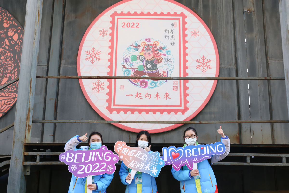 2月2日，冬奥城市志愿者与展出的冬奥主题年画合影。中国日报记者 武晓慧 摄