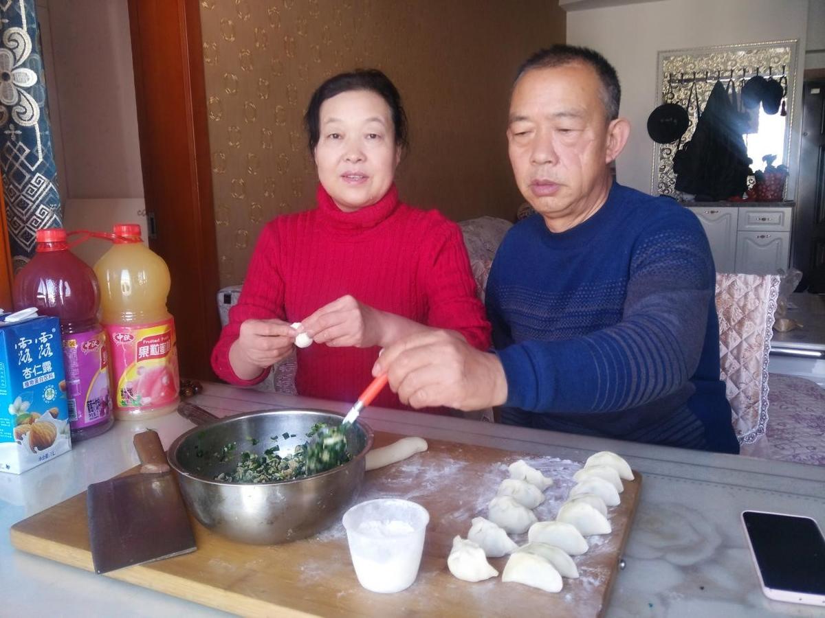 图为：腊月二十八，李宜蓉父母在家包饺子