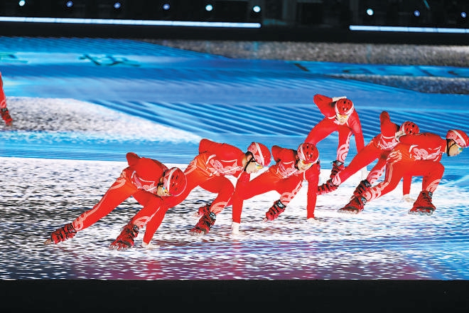 “更快、更高、更强——更团结”的奥运口号，随着滑冰运动员的矫健身影映射在“鸟巢”。 (李尕 摄)