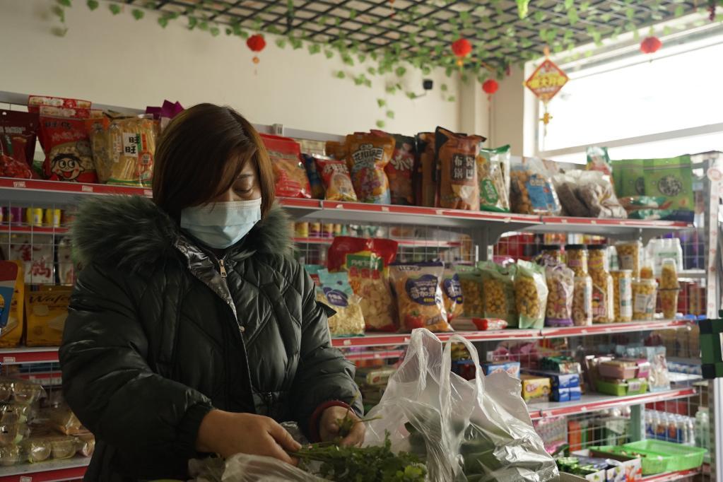 1月27日，超市老板段志英在整理售卖的蔬菜。（新华社记者 陈杰 摄）