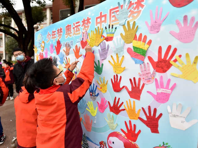 合肥市六安路小学学生将“梦想手掌”贴到印有奥运五环图案的主题板上，表达对祖国和运动健儿的祝福。葛传红 摄