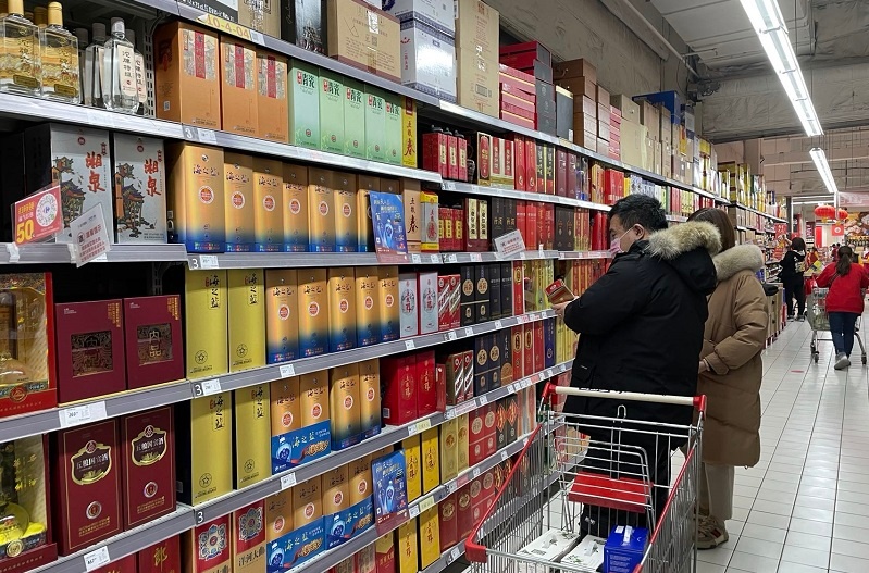 北京某超市的白酒展柜前,消费者在选购酒品.