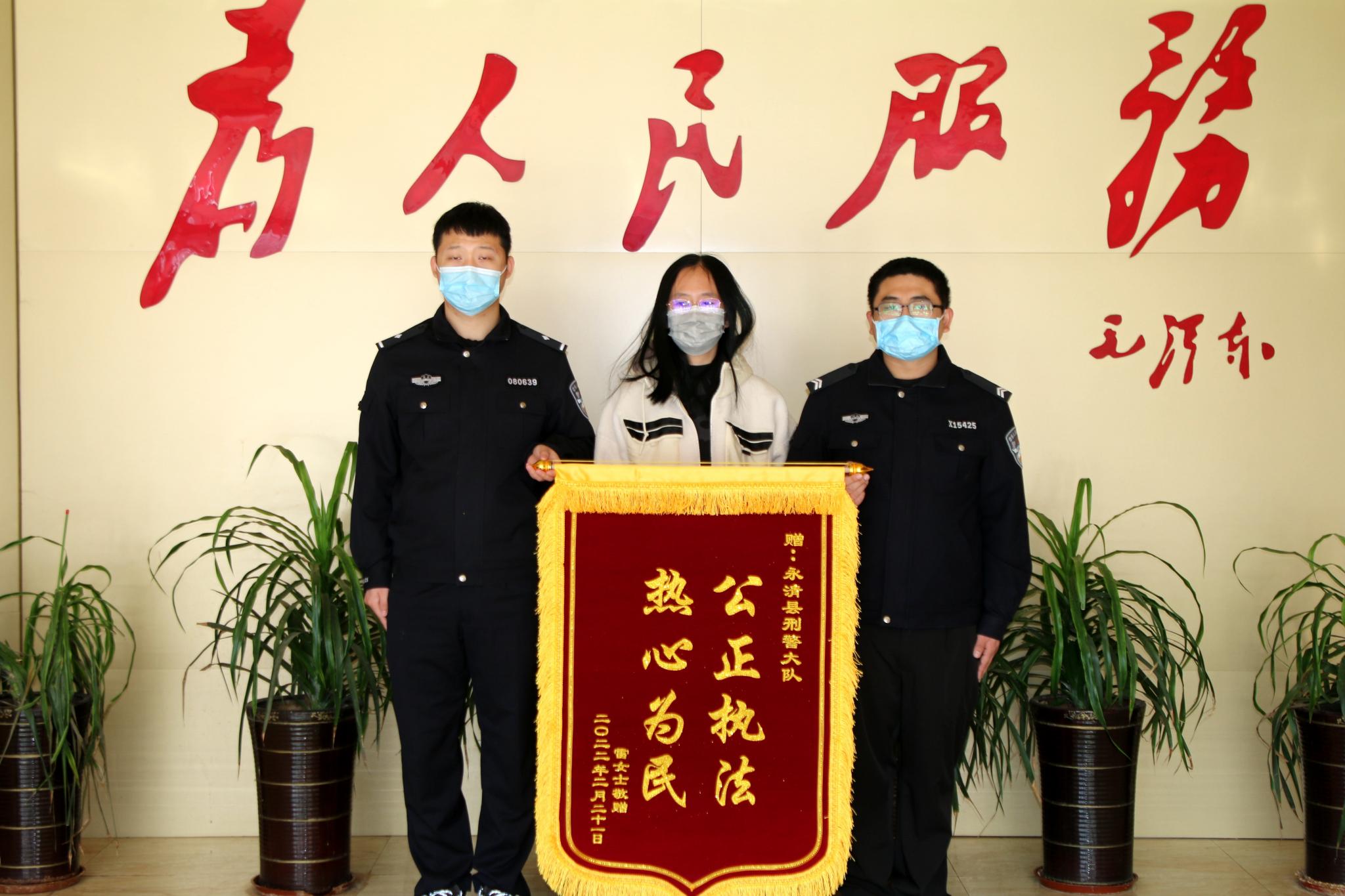 图为受害人雷某将一面写有"公正执法 热心为民"的锦旗送到永清县办案