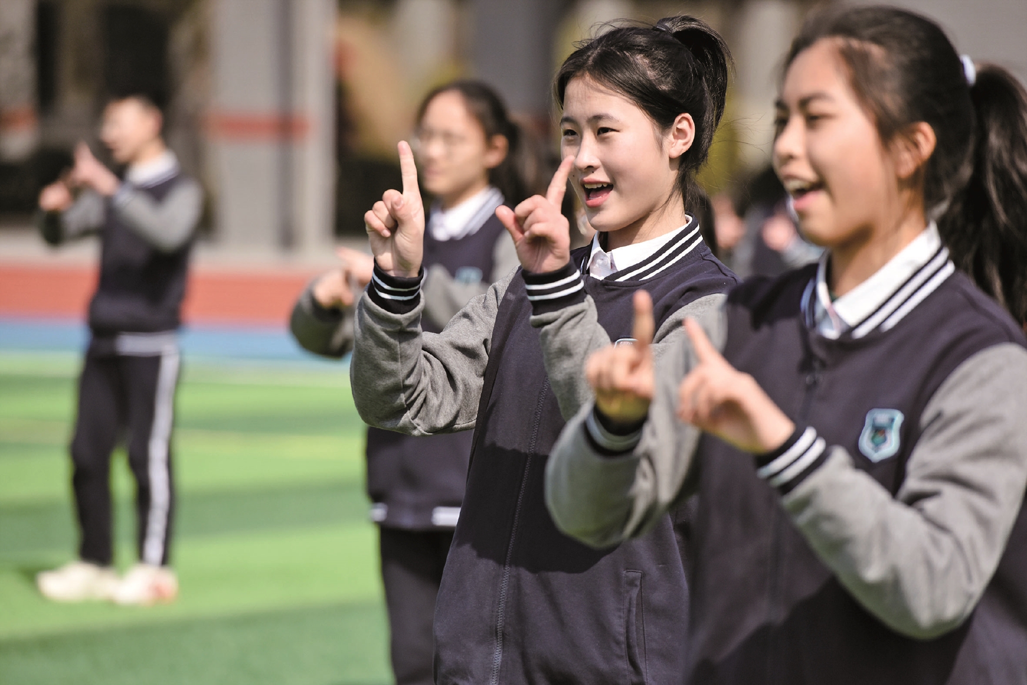 学生们利用午休时间,跟着欢快的音乐跳起了北京冬奥会手势舞《一起向