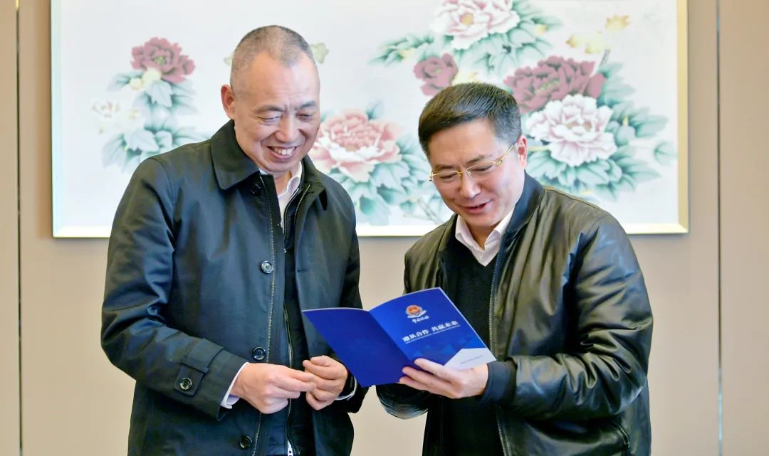 图为国家税务总局四川省税务局党委书记,局长李杰(右一)向企业赠送"税