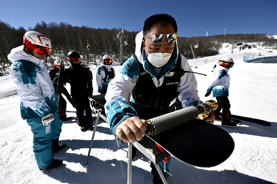 3月2日，中国队打蜡师米文良在为雪板打蜡。中国日报记者 魏晓昊 摄