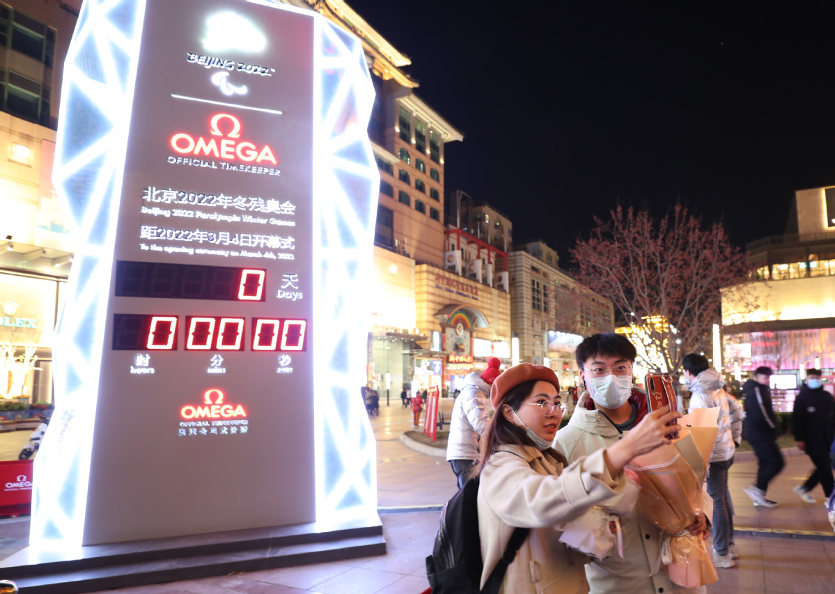 3月4日晚，市民在冬残奥会倒计时牌前自拍留念。中国日报记者 邹红 摄