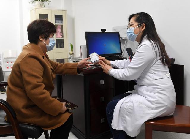 在广西壮族自治区妇幼保健院，杜丽群（左）向阮毅燕医生了解罕见疾病用药及其价格情况。新华社记者 陆波岸 摄