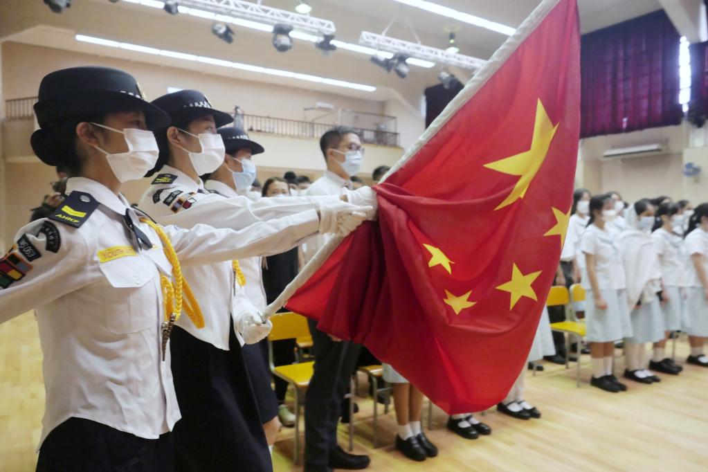 在香港教育工作者联会黄楚标中学，白衣蓝帽护旗升旗小队正步走向旗杆（2021年9月1日摄）。新华社记者 王申 摄