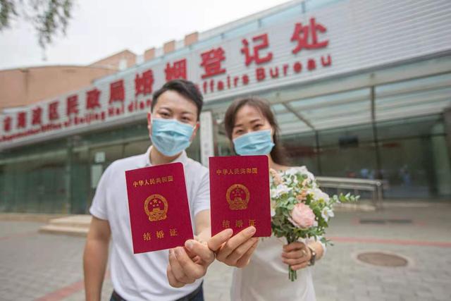 一对新人展示他们的结婚证.新京报记者 郑新洽 摄