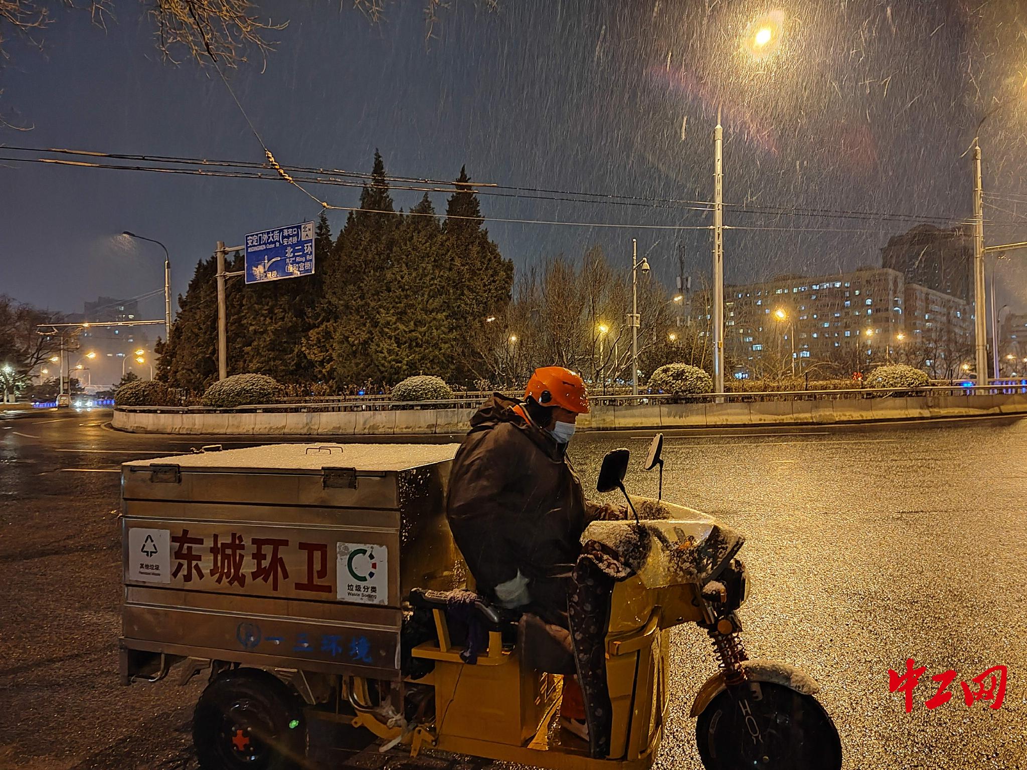 北京安定门,雨雪中还未下班的环卫工. 刘云摄
