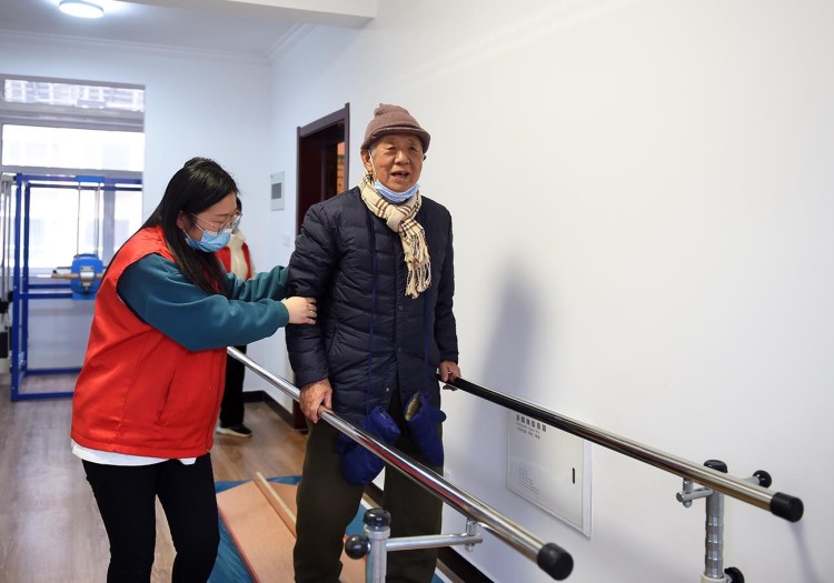 近日,在河北省宁晋县宁纺东城社区老年日间照料中心,志愿者陪老人锻炼